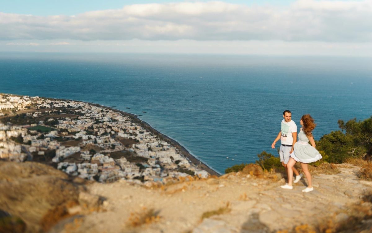 Couple on a hilltop path at Ancient Thira, above Kamari and its long black beach