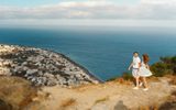 Couple on a hilltop path at Ancient Thira, above Kamari and its long black beach