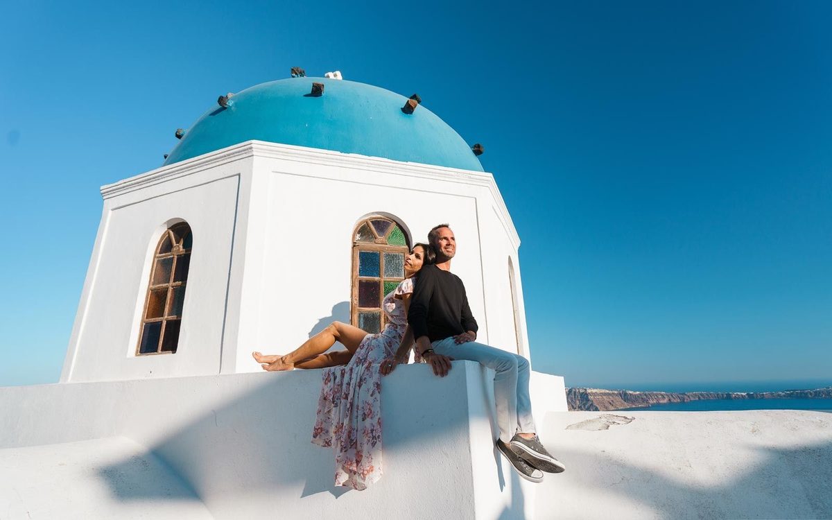 Couple sitting against a blue-domed chapel with stained-glass windows