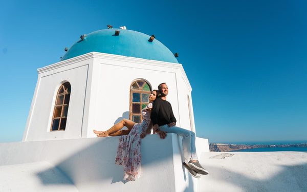 Couple sitting against a blue-domed chapel with stained-glass windows