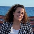 Chrysa, a Greece Holiday Tours guide, smiling by the sea