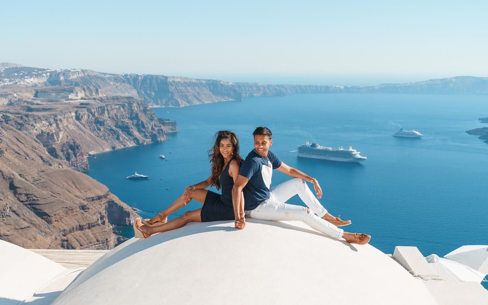 Couple sitting on the roof in Imerovigli village
