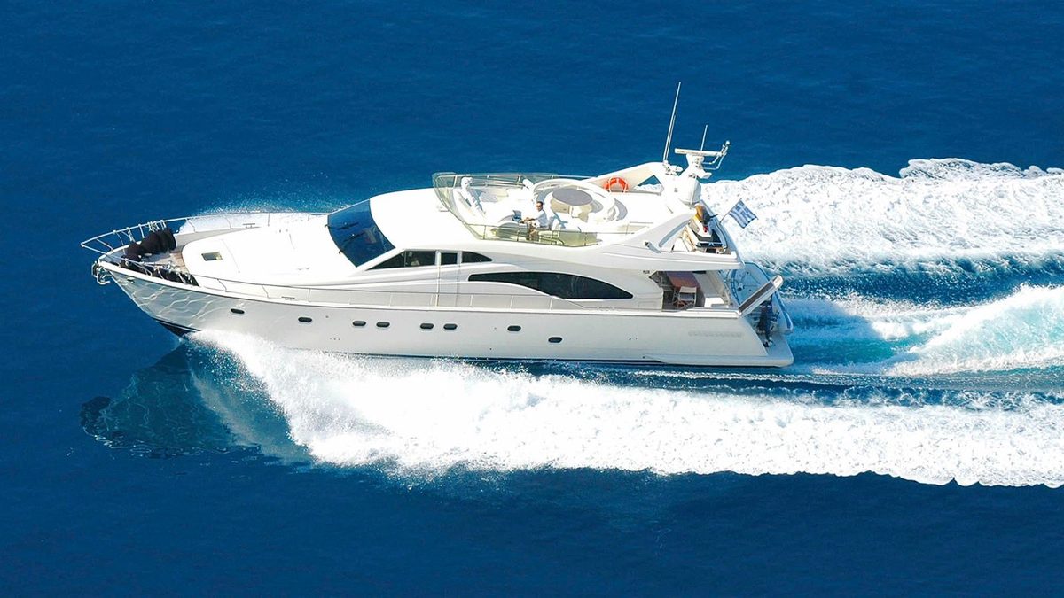 White luxury motor yacht cruising at speed on deep blue sea