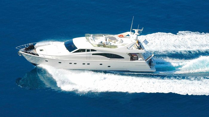 White luxury motor yacht cruising at speed on deep blue sea