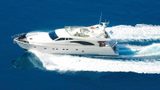 White luxury motor yacht cruising at speed on deep blue sea