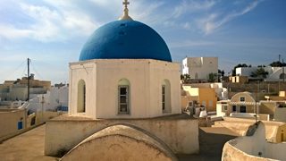 Blue-domed church above the rooftops of Megalochori