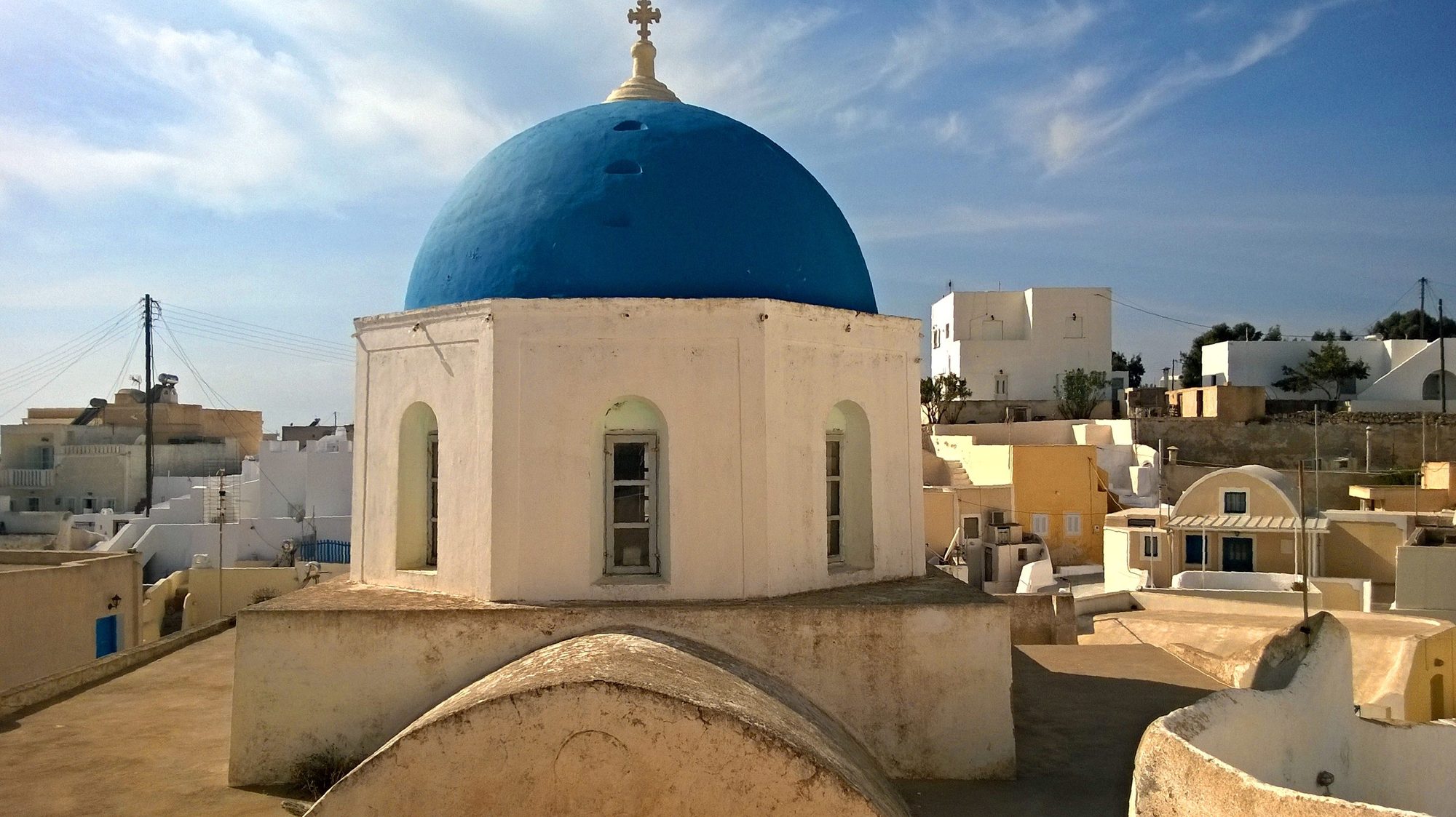 Blue-domed church above the rooftops of Megalochori
